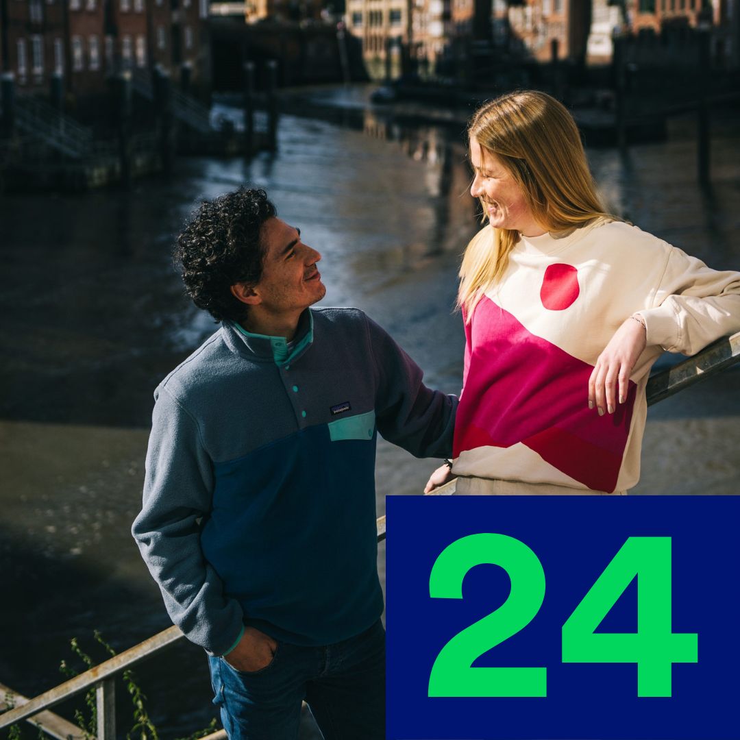 Türchen 24: Zwei Menschen posieren an einem Flussufer.