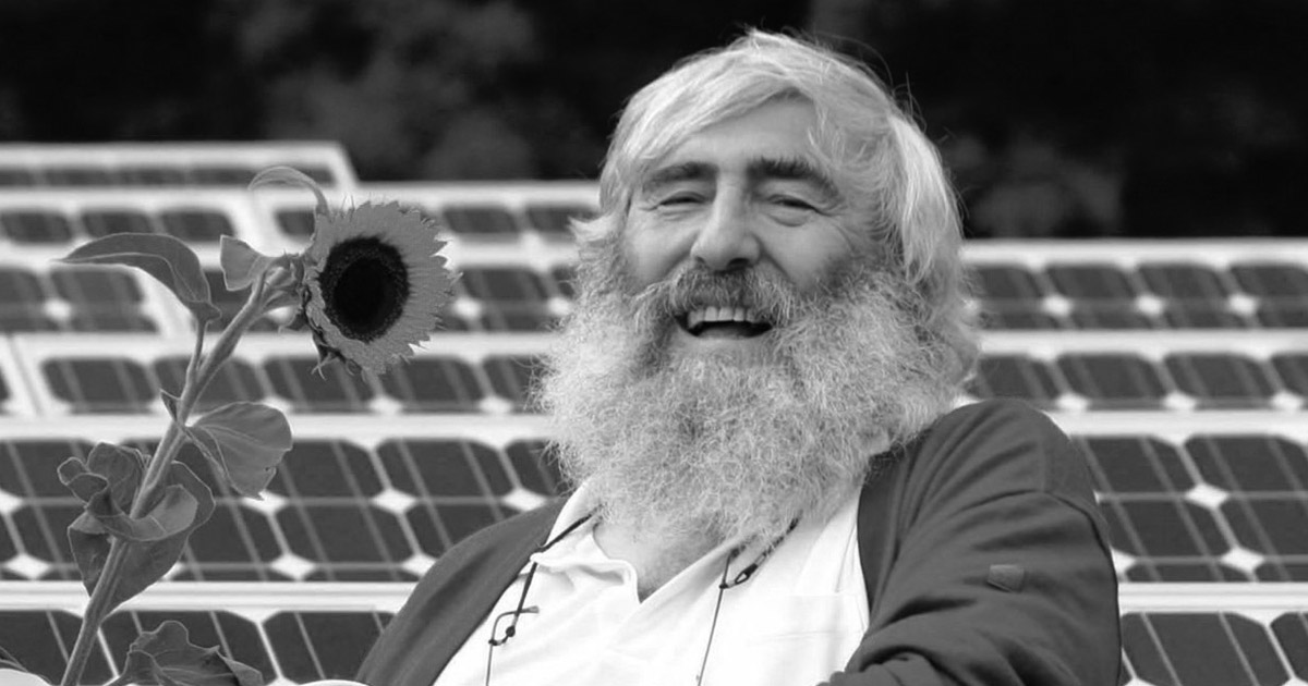 Michael Sladek in einem Solarpark mit Sonnenblume.