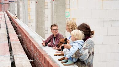 3 weiblich gelesene Personen und ein Kleinkind auf einer Baustelle