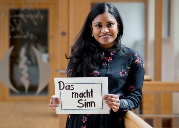 Mitarbeiterin der GLS Bank mit Plakat "Das macht Sinn"