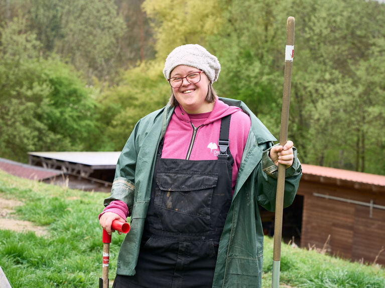 Frau mit Gartenwerkzeug im inklusiven Projekt Laufenmühle.