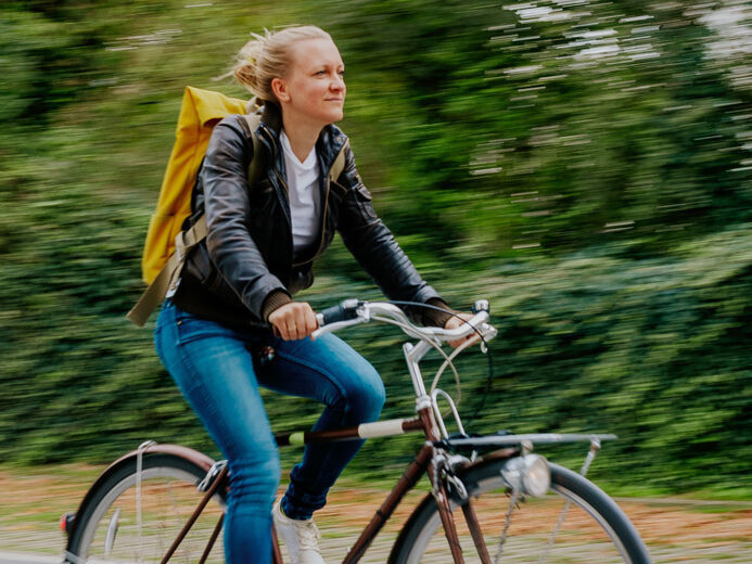 Frau fährt auf Fahrrad, Bewegungsunschärfe im Bild