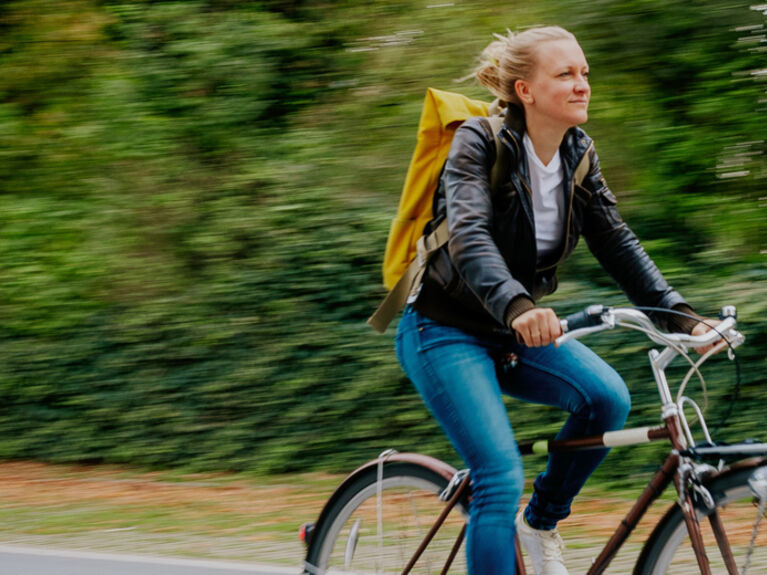 Frau fährt auf Fahrrad, Bewegungsunschärfe im Bild