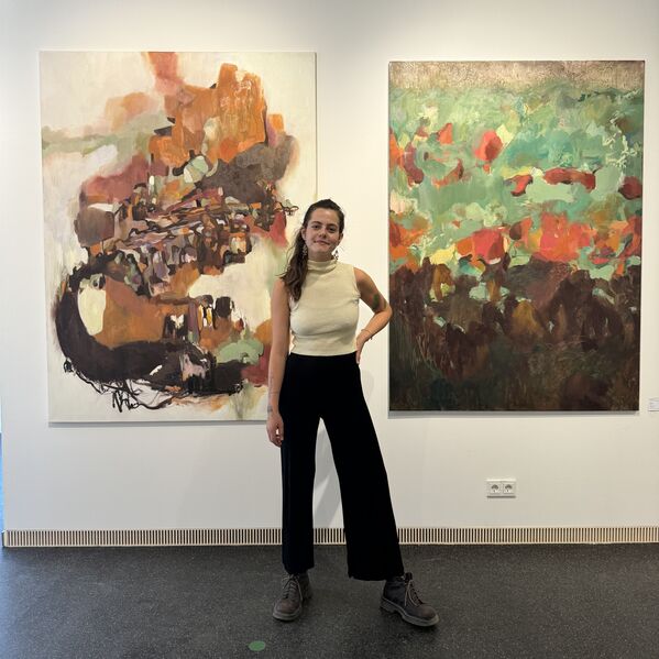 Bild von Marie Hesse vor zwei Kunstwerken Bild von Marie Hesse vor zwei Kunstwerken