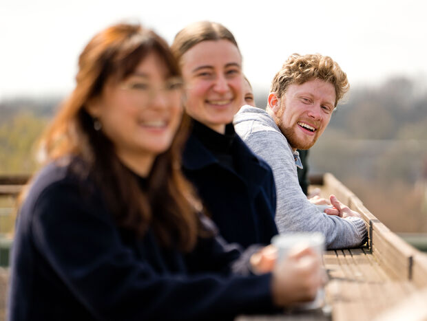 Drei Mitarbeitende der GLS Bank auf einem Aussichtsturm beim Teambuilding.