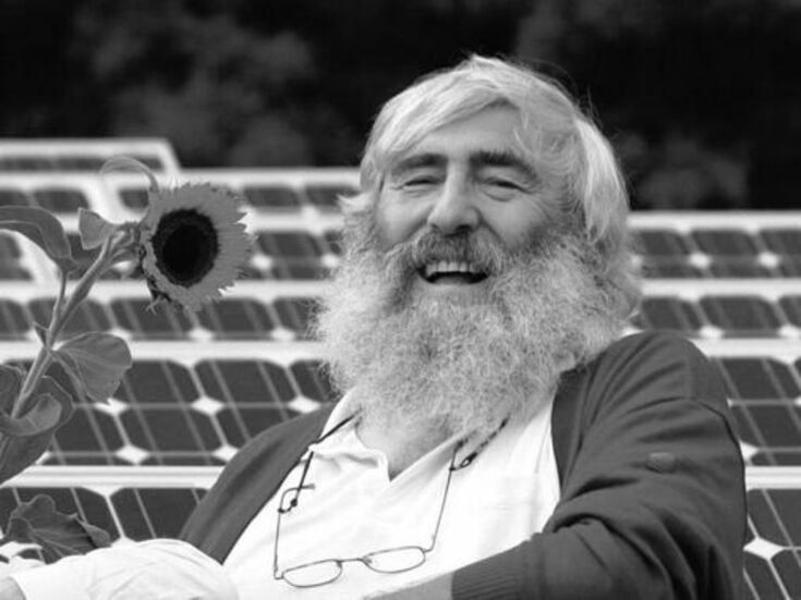 Michael Sladek in einem Solarpark mit Sonnenblume.