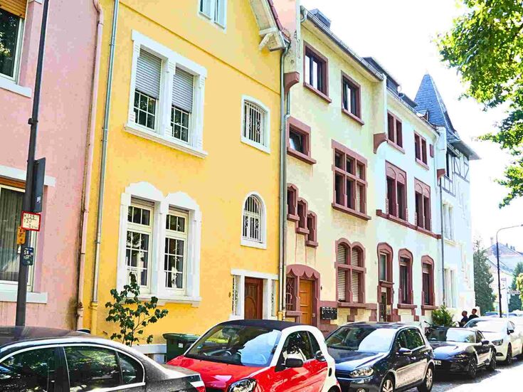 Straße in einer Stadt mit geparkten Autos und Häusern.