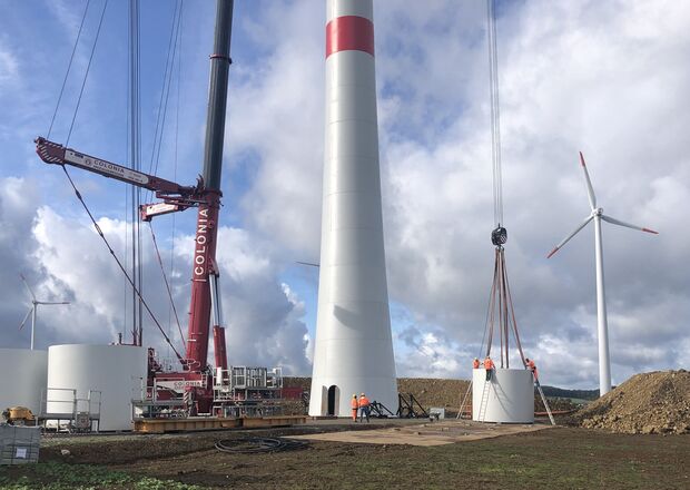 Bauarbeiten an Windkraftanlagen mit einem Kran.