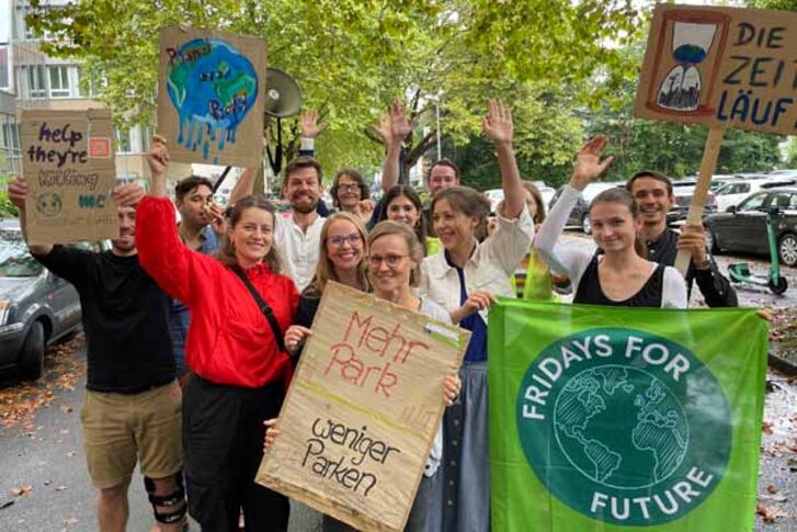 Mitarbeiter*innen der GLS Bank zeigen ihre Protestschilder zum Klimastreik